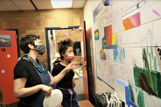 Two volunteers looking at a mural design