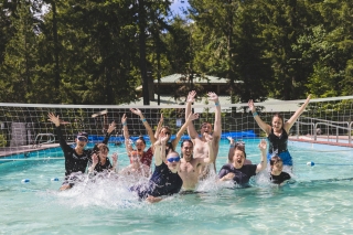 Young people playing pool volleyball