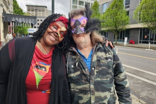 Two people standing outside wearing festive masks