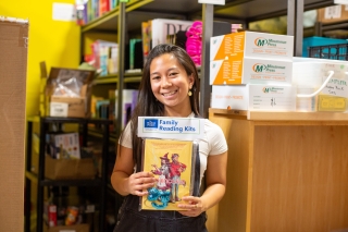 A young person holding up Family Reading Kits