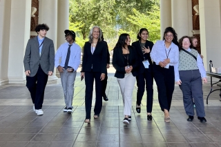 Business students walk with volunteers through a corridor