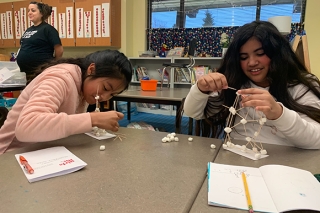 Two girls working on a project in a classroom
