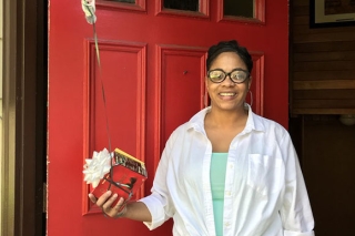 Photo of a woman receiving an appreciation in front of a red door