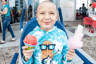 Photo of a child with holding a snow cone and cotton candy