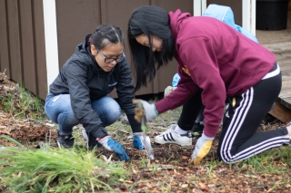 Photo of two girls planting in a garden