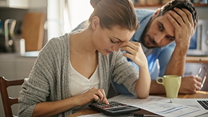 Thumbnail image of man and woman sitting at table calculating bills.